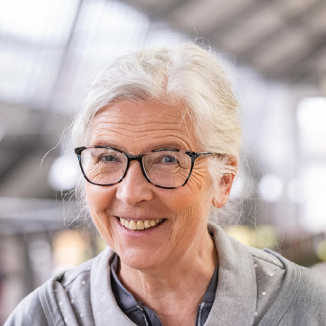 Porträtfoto: Marianne Schweinesbein. Sie trägt eine dunkle Brille und die langen weißen Haare hochgesteckt.